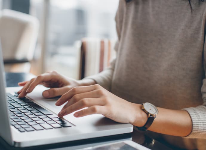 Mãos femininas digitando.