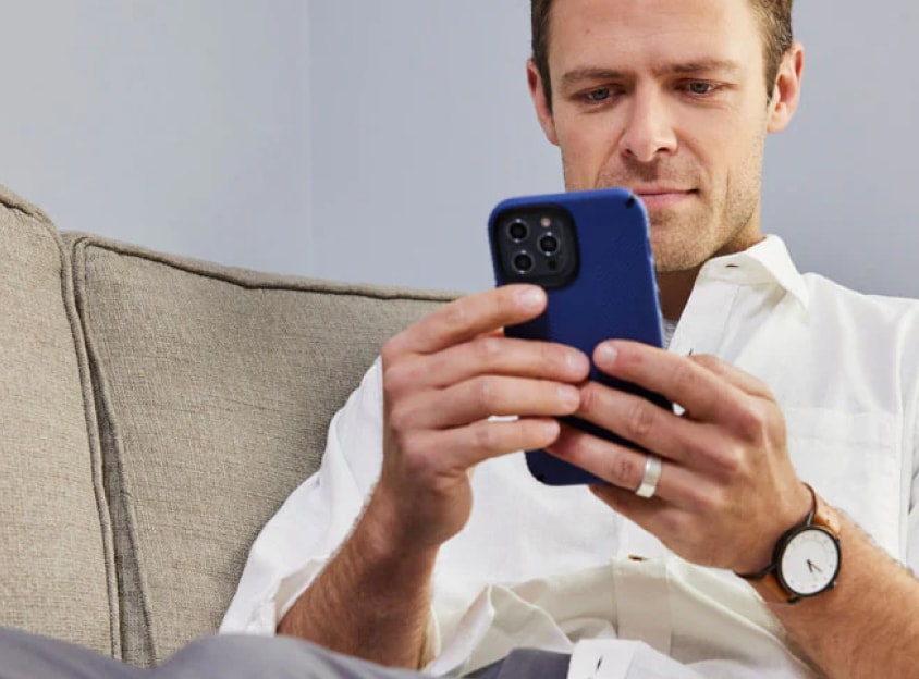 Homem no sofá navegando no celular.