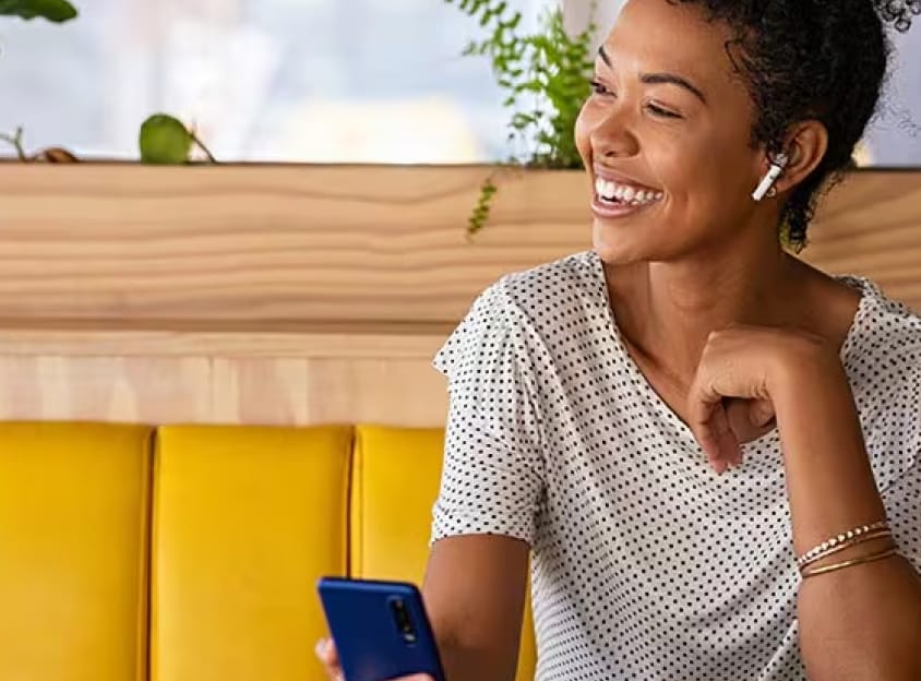 Mulher sentada sorrindo em uma chamada.