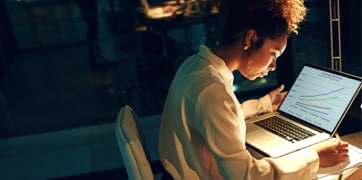 Mulher sentada em frente a um laptop